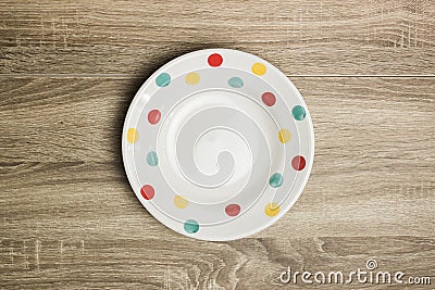 A cute empty plate on a wooden table. Stock Photo