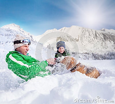 Cute family scene: father and son play with dog during mountain Stock Photo