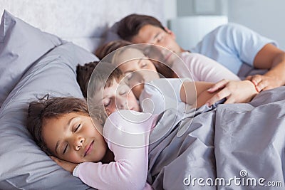 Cute family sleeping in bed Stock Photo