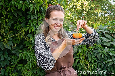 A cute farmer girl holds a small pumpkin in her hands Stock Photo