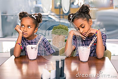 Cute fashionable sisters wearing nice bright bracelets feeling bored Stock Photo