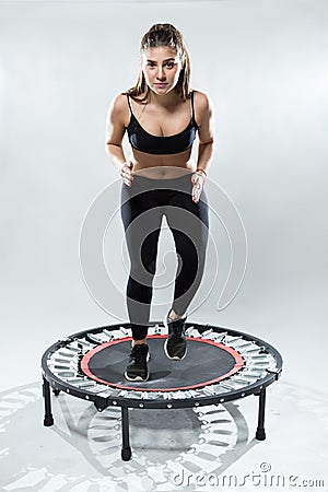 Cute fitness-girl make exercise on rebounder Stock Photo