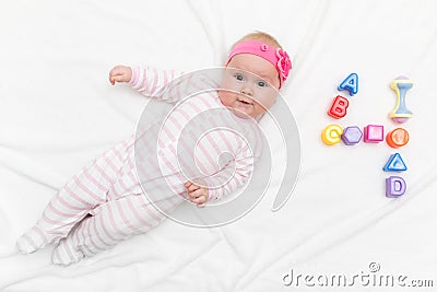 Cute four month old baby wrapped into towels after shower in bed at home Stock Photo