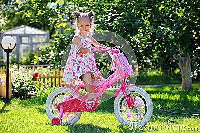 Cute four-year old girl riding her bicycle Stock Photo