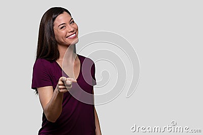 Cute fun beautiful brunette mixed ethnicity female portrait, pointing finger at camera with an adorable smile Stock Photo