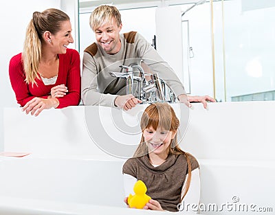 Funny girl looking at her parents while sitting in a bathtub i Stock Photo