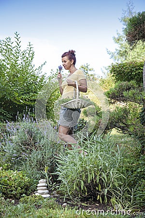 Cute gardener smelling organic herbs Stock Photo