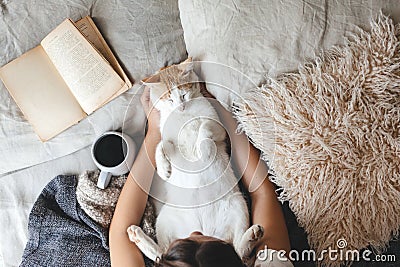 Hygge concept with cat, book and coffee in the bed Stock Photo