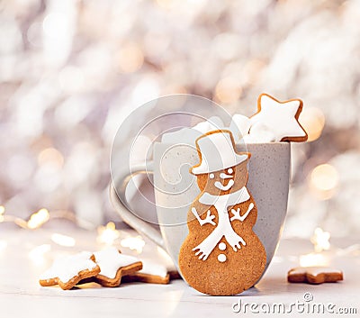 Cute Gingerbread Snowman Cookie in front of Hot cocoa with Marshmallows Stock Photo