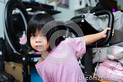 A cute girl aged 4-5 years old is holding rice in her cheek and playing climbing. Children wear pink t-shirts Stock Photo