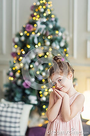 Cute girl on the background of the Christmas tree. portrait of a child in the new year interior Stock Photo