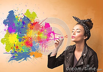 Cute girl blowing colorful splash graffiti Stock Photo