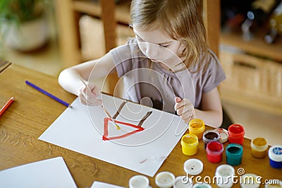 Cute girl is drawing with paints in preschool Stock Photo
