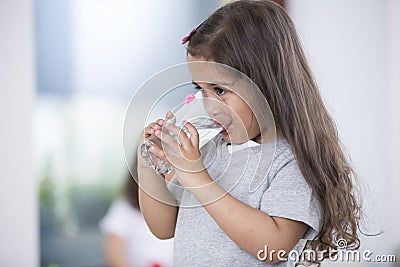 Cute girl drinking glass of water at home Stock Photo