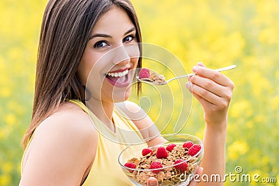 Cute girl eating healthy cereal breakfast outdoors. Stock Photo