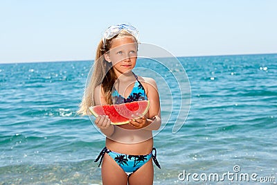 Cute girl eating watermelon on beach. Stock Photo