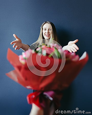 Cute girl getting bouquet of red tulips. Boyfriend giving tulips. Stock Photo