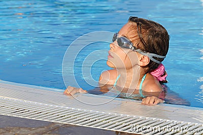 Cute girl in goggles swimming in pool Stock Photo