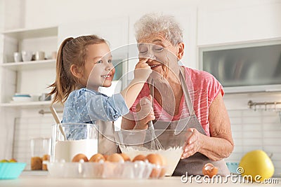 Cute girl and her grandmother cooking Stock Photo