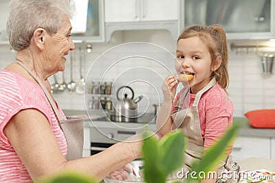 Cute girl and her grandmother cooking Stock Photo