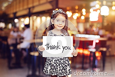 Cute girl holding a piece of paper with the words Thank You Stock Photo