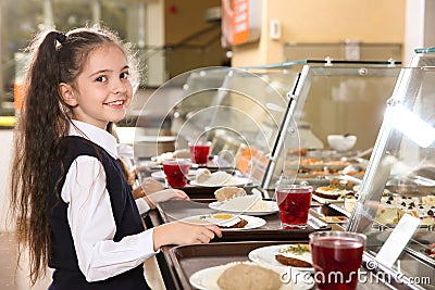 Cute girl near serving line with healthy food in canteen Stock Photo