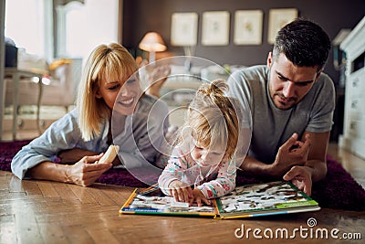 Cute girl with parents play with puzzle indoor Stock Photo