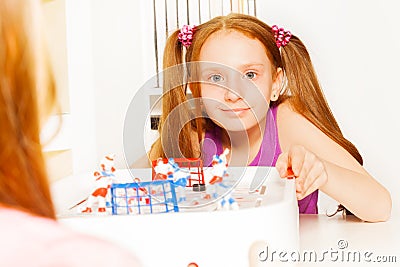 Cute girl playing ice hockey table board game Stock Photo