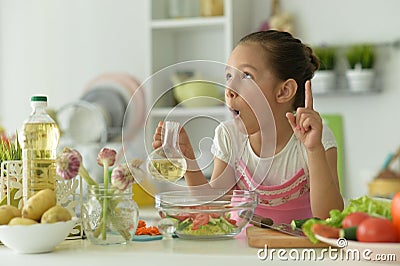 Cute girl preparing delicious fresh salad in kitchen Stock Photo