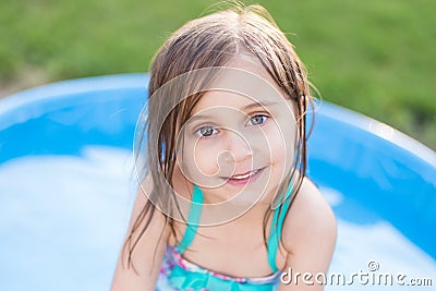 Girl smiling in kiddie pool Stock Photo