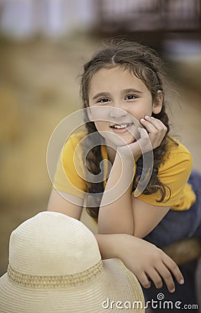 Cute girl in a straw hat, sitting in a field of hay in Eagle Mountain, Ut. Stock Photo