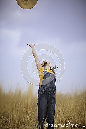 Cute girl in a straw hat, sitting in a field of hay in Eagle Mountain, Ut. Stock Photo