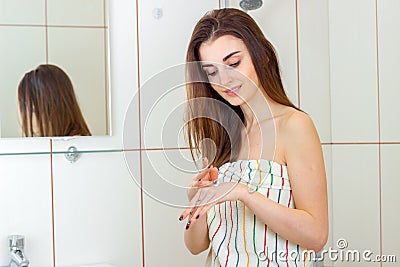 Cute girl in towel causes cream on hand Stock Photo