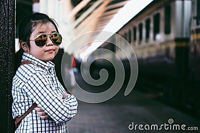 Cute girl in train station waiting to travel. Summer holiday. Stock Photo