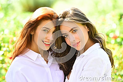 Cute girls, cheerful best friends, sisters party on nature having fun. Girls hugging. Sexy look, beautiful wavy hair. Stock Photo