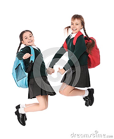 Cute girls in school uniform jumping on white Stock Photo