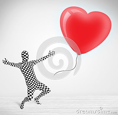 Cute guy in morpsuit body suit looking at a balloon shaped heart Stock Photo