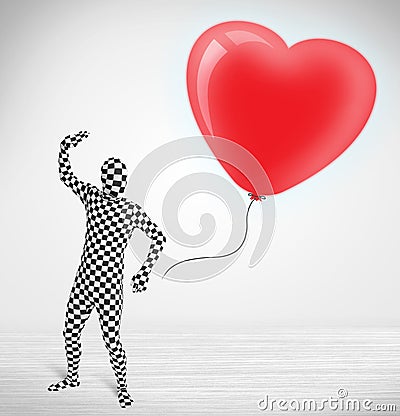 Cute guy in morpsuit body suit looking at a balloon shaped heart Stock Photo