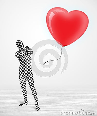 Cute guy in morpsuit body suit looking at a balloon shaped heart Stock Photo