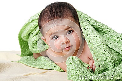 Cute happy baby between green blankets Stock Photo