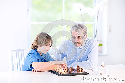 Cute happy boy playing chess with his grandfather Stock Photo