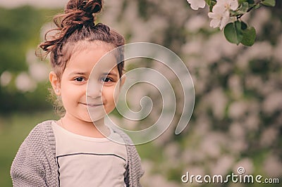 Cute happy dreamy toddler child girl walking in blooming spring garden, celebrating easter outdoor Stock Photo