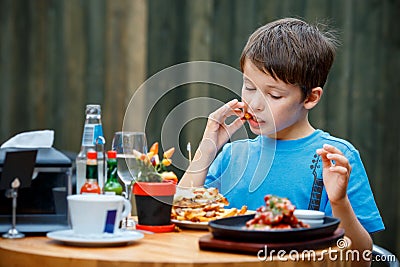 Cute healthy teenager boy eats hamburger and potato Stock Photo
