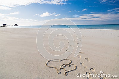 Heart shape drawing in the sand on tropical beach, romantic and honeymoon concept background for couples Stock Photo