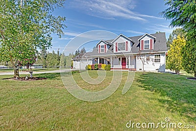 Cute home exterior with red shutters on a summer day. Stock Photo