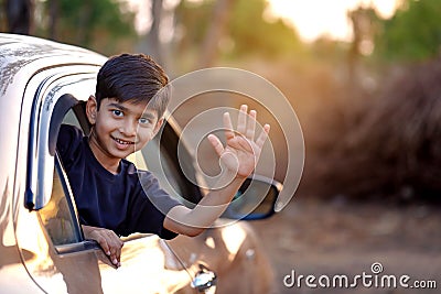 Cute Indian Child waving from car window Stock Photo