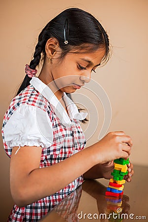 Cute Indian kid playing with puzzle toys Stock Photo