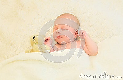 Cute infant sleeping together with teddy bear toy on bed home Stock Photo