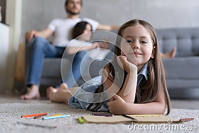 Cute kid girl playing on floor, preschool little girl drawing with colored pencils on paper spending time with family Stock Photo