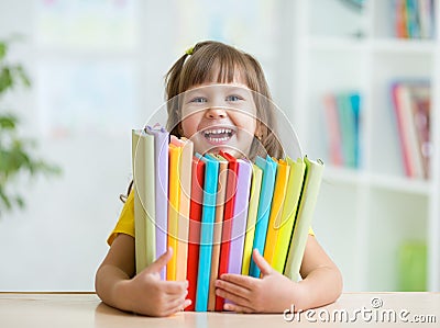 Cute kid girl preschooler with books indoor Stock Photo